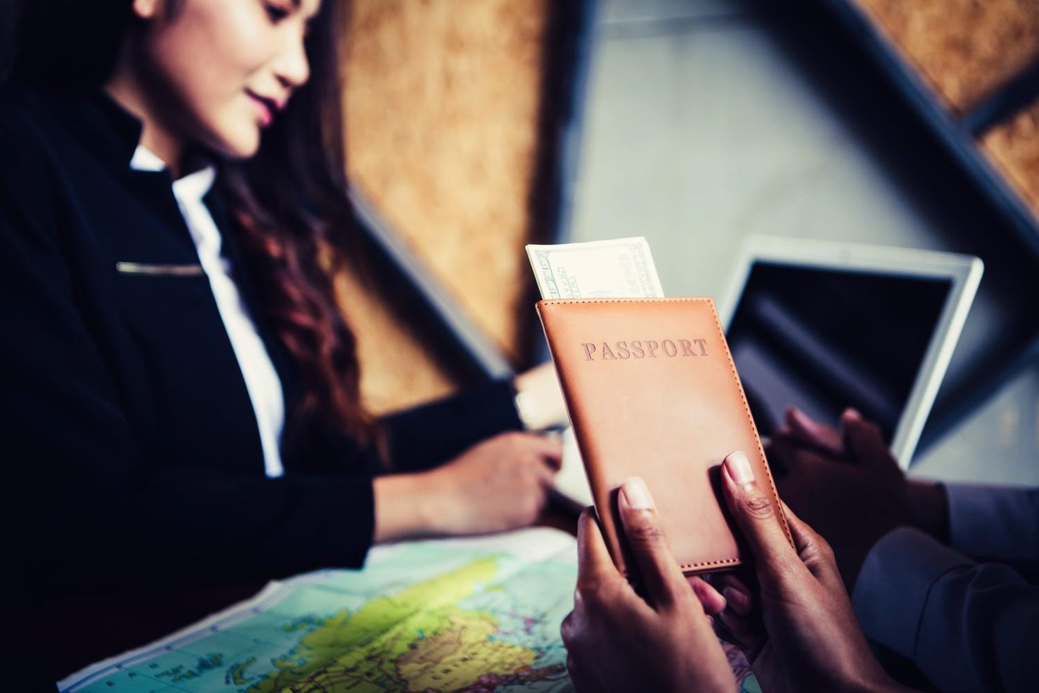 Couple Getting Travel Guidance With Passport From Travel Agent