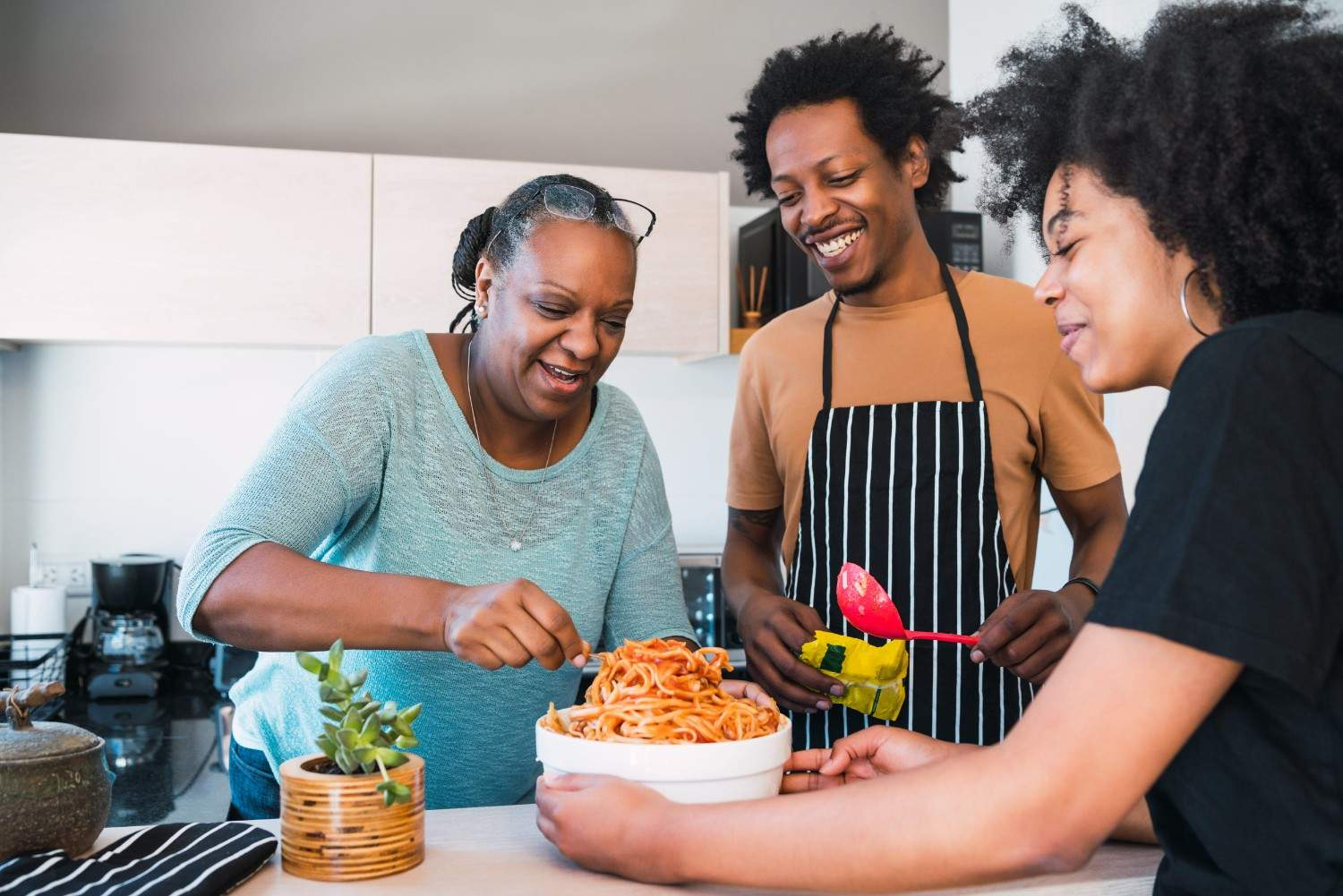 Family Cooking Pasta Together In The Kitchen