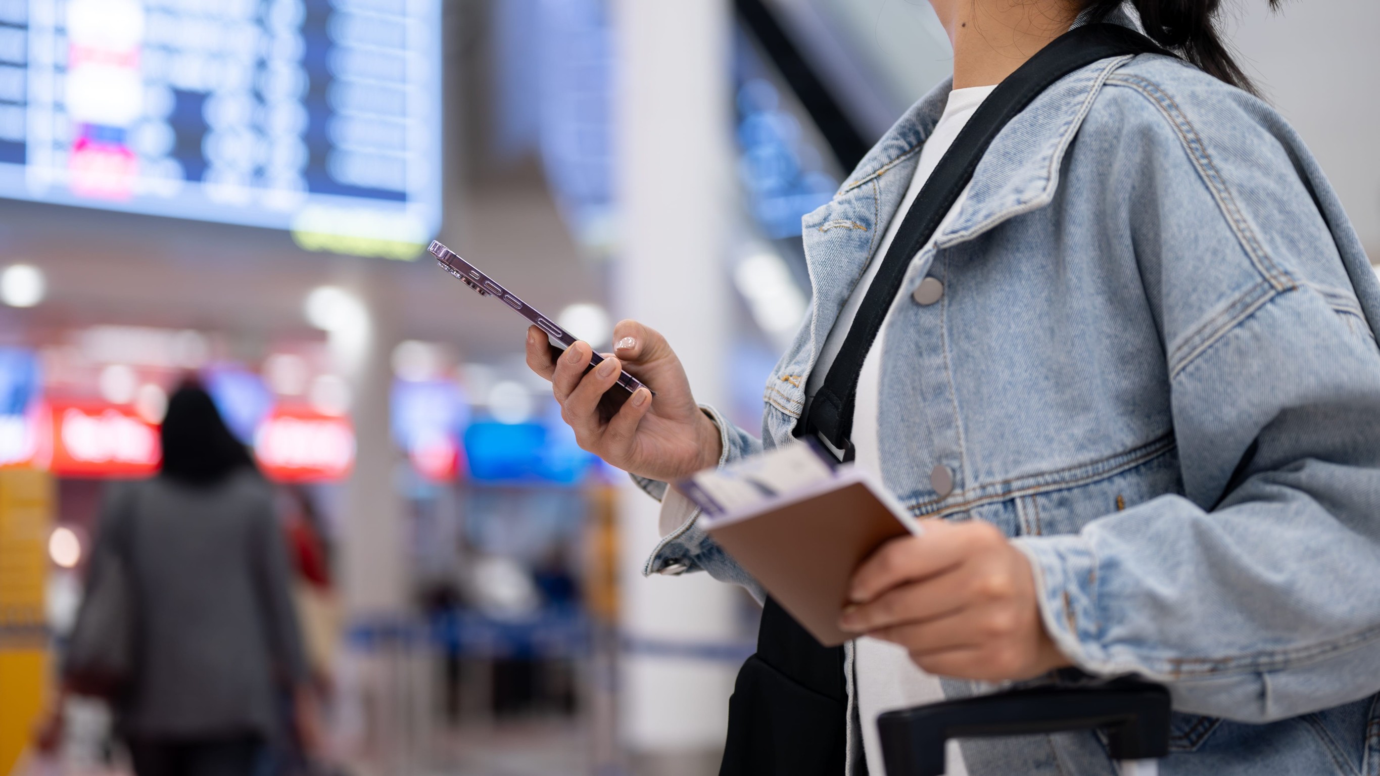 Female Passenger Standing in the Airport Terminal with a Passport