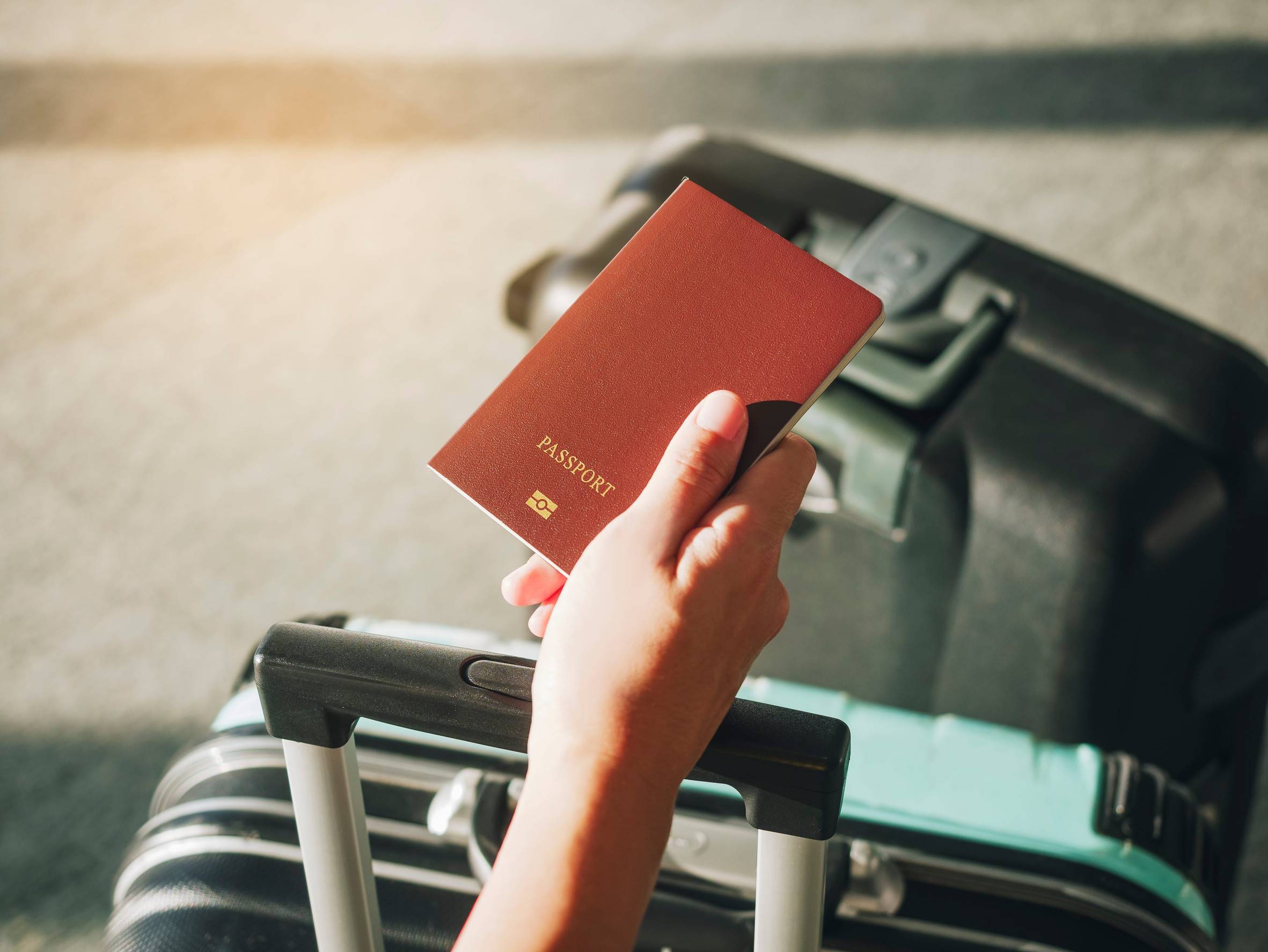 Hand Holding Passport Traveler With Luggage