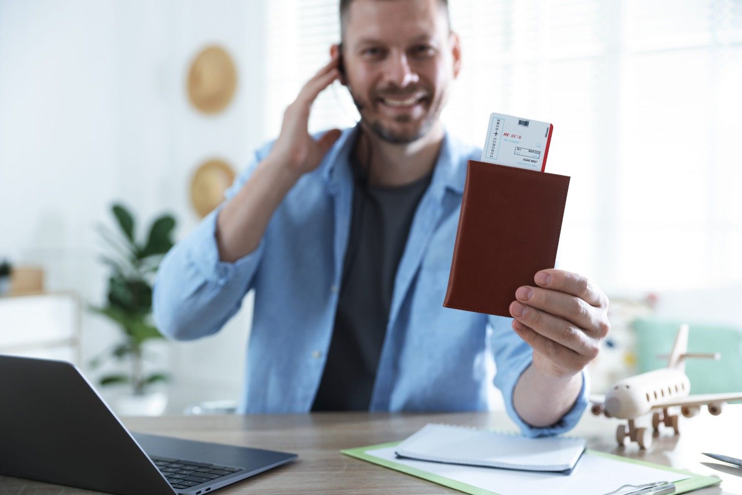 Travel Agent With Passport And Ticket At Wooden Table