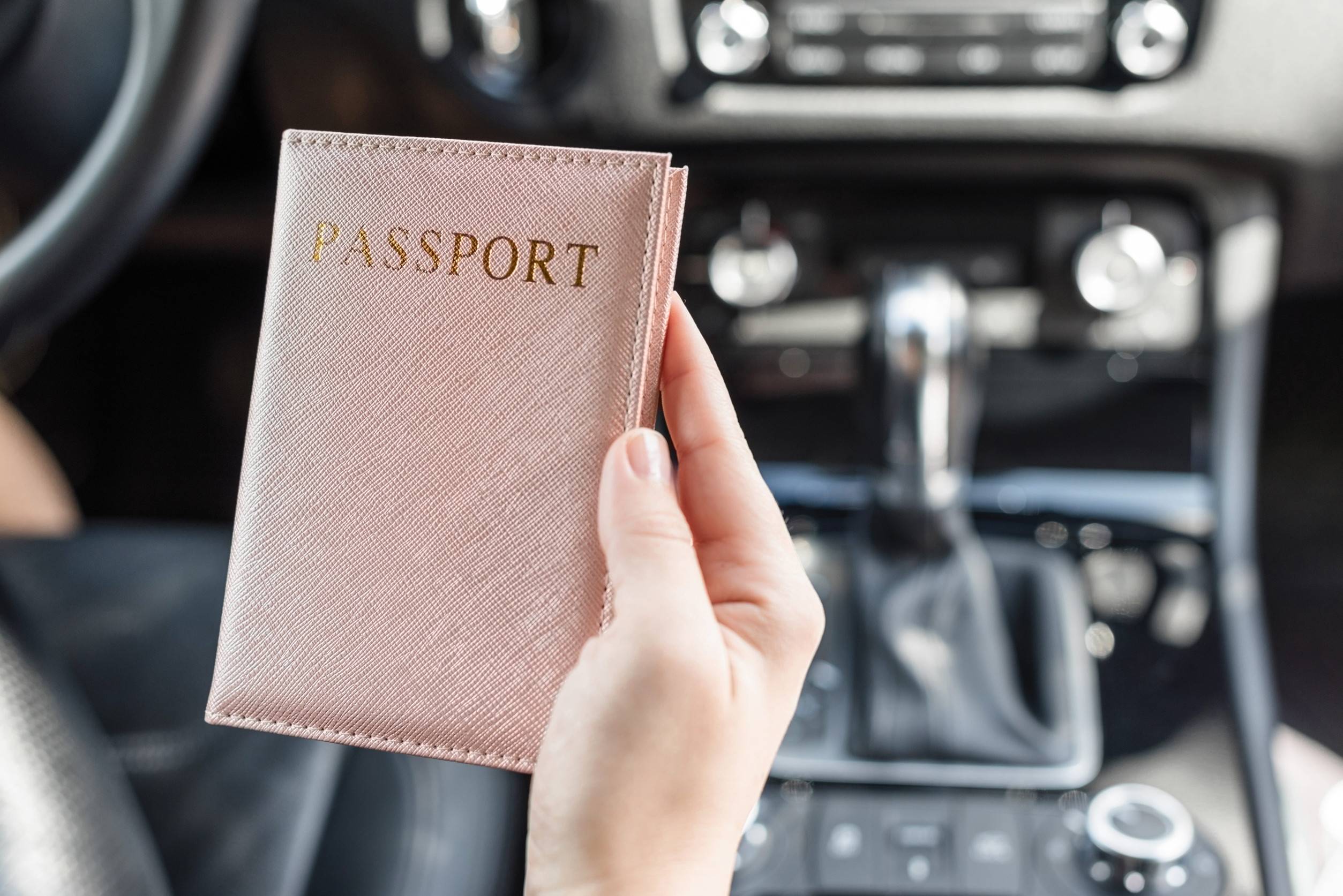 Woman With Passport In Pink Cover Sitting In Car