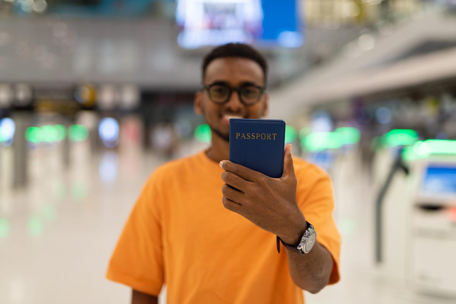 Young Man at Airport Terminal with Passport